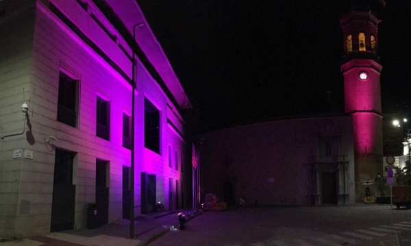 Auntamiento y campanario iluminados de color violeta contra la violencia de género